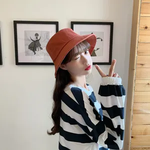 Asian female model wearing a bright orange minimalist bucket hat for summer sun protection