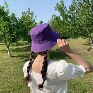 Back view of a minimalist purple bucket hat for sun protection in an outdoor park