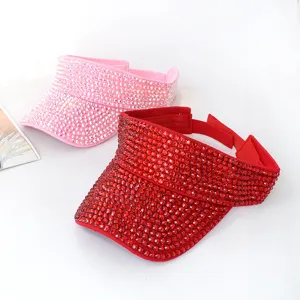Primo piano di visiere parasole in strass luccicanti nei vivaci colori rosa e rosso