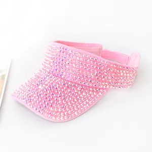 Dettaglio di una visiera rosa da donna interamente ricoperta di strass luccicanti.