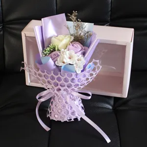 Eleganter lila Seifenblumenstrauß mit Rosen und Nelken in einer rosa Geschenkbox