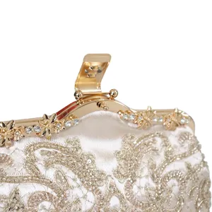 Detailansicht einer champagnerfarbenen bestickten Abendtasche mit Strass-Goldrahmen