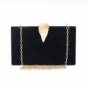Elegant black velvet evening clutch bag featuring a gold leaf clasp and delicate chain strap.