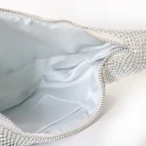 Dettaglio interno di una borsa da sera con strass e fodera in raso argento
