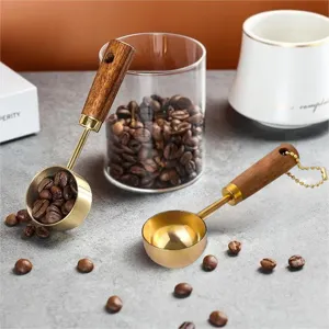 Detailed view of gold-plated coffee measuring spoons with premium walnut wood handles.