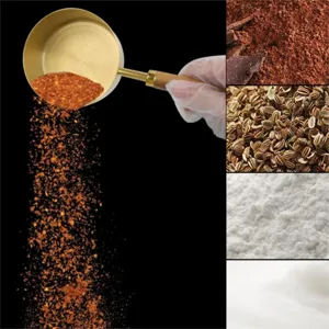 Close-up detail of a gold-plated stainless steel measuring spoon pouring red spice