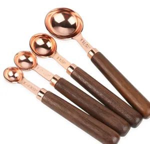 Set di misurini in acciaio inossidabile oro rosa con manici in legno, vista dettagliata.