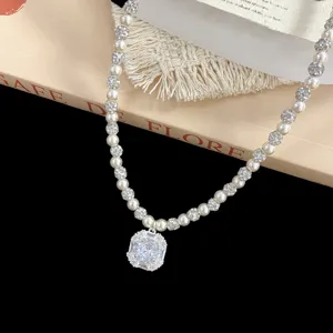 Dettaglio di una collana di lusso con pendente a diamante quadrato e perle