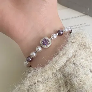 Close-up of elegant purple square zircon pearl bracelet worn on a model's wrist