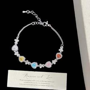 Vista detallada de pulsera de plata con circonitas de colores en forma de corazón