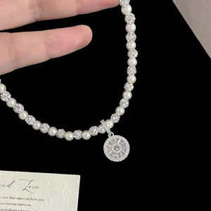 Détail en gros plan du collier boussole de luxe en perles et zircons avec pendentif rond