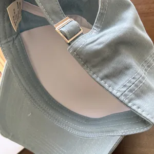 Detailweergave van de vintage pet met de verstelbare metalen band en het label.