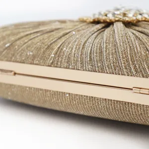 Elegant champagne gold evening clutch with pleated texture and rhinestone detail