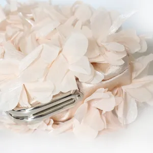 Elegant close-up of champagne flower evening bag with 3D fabric petals and silver clasp