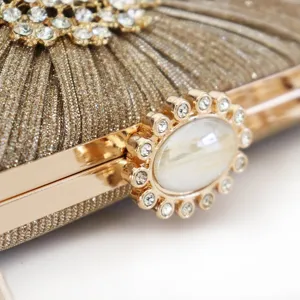 Elegant gold pleated clutch bag with rhinestone floral buckle and marble accent