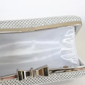 Silver rhinestone evening clutch bag with bowknot clasp and white satin interior