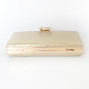 Elegant champagne gold glitter evening clutch bag with decorative jeweled ring clasp