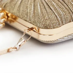 Close-up of gold sparkling evening clutch bag with elegant metallic frame