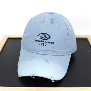 Detail of light blue distressed baseball cap with 1989 letter embroidery