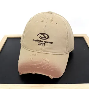 Detailed view of distressed khaki baseball cap with 'Lost in the moment' embroidery