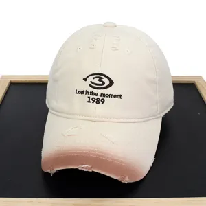 Close-up of distressed beige baseball cap with 'Lost in the moment 1989' embroidery