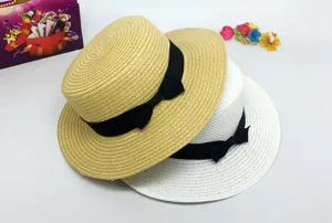 Stylish women's flat top straw hat with black bow, perfect summer beach sun protection.