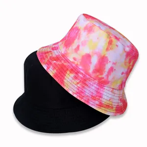 Close-up detail of reversible bucket hats, featuring tie-dye pink and solid black styles.