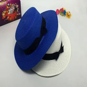 Detailed view of summer straw hat with black bow, flat top design, elegant sun protection style.
