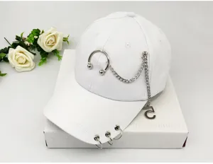 Close-up of white baseball cap with punk metal chain and brim rings decoration