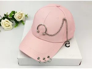 Detailed view of pink baseball cap with decorative silver chains and metal rings