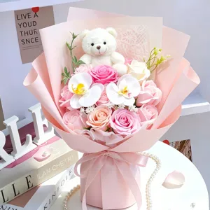Nahaufnahme eines rosa Seifenrosenstraußes mit einem niedlichen weißen Teddybären