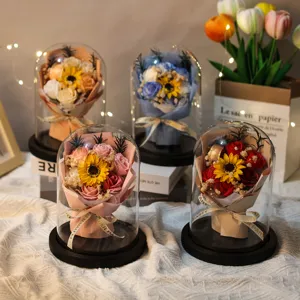 Detailed view of four soap flower bouquets inside glass domes with warm LED lights