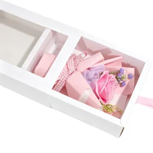 Détail élégant d'un bouquet de roses en savon rose dans une boîte cadeau blanche à tiroir
