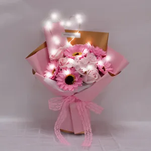 Primer plano de un ramo de girasoles de jabón rosa con luces LED cálidas para decoración