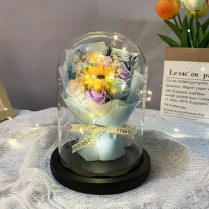 Macro view of glowing soap flower bouquet inside a large glass dome with LED lights.