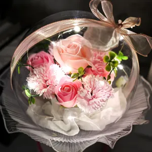 Gros plan d'un bouquet de roses en savon dans une bulle acrylique avec LED