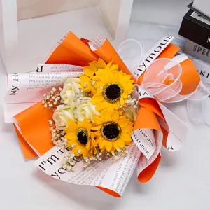 Detailed close-up of an artificial sunflower and rose bouquet with vibrant orange wrapping