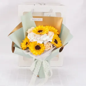 Primer plano de ramo de flores de jabón de girasol e rosa en una bolsa de regalo blanca
