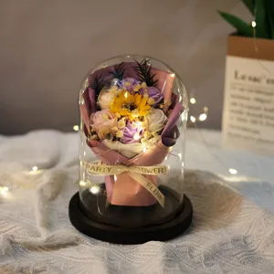 Macro view of soap flowers in glass dome with warm LED lights gift decoration