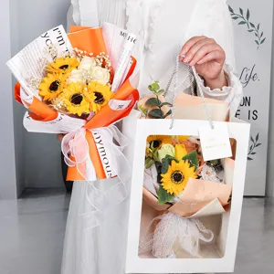 Handheld artificial sunflower bouquet with elegant white gift bag for graduation gift