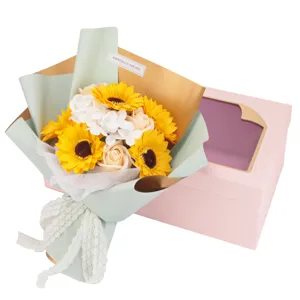 Ramo de flores de jabón detallado con girasoles y rosas junto a una caja de regalo