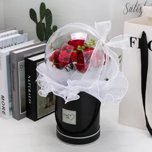 Détail d'un bouquet de roses de savon et d'œillets rouges dans une boîte acrylique bobo