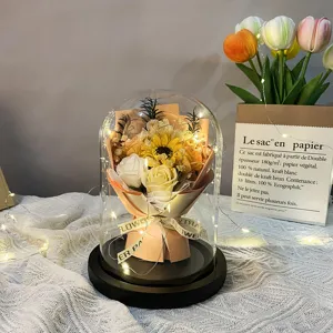 Elegant sunflower and white rose soap flower bouquet in glass dome with warm LED fairy lights