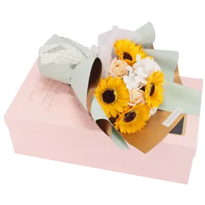 Primer plano de un ramo de flores de jabón de girasol y rosa en caja de regalo rosa
