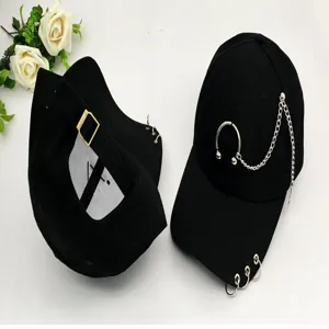 Close-up detail of black baseball cap featuring silver metal rings and hanging chain.