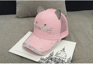 Detailed view of pink rhinestone cat ear hat on decorative book