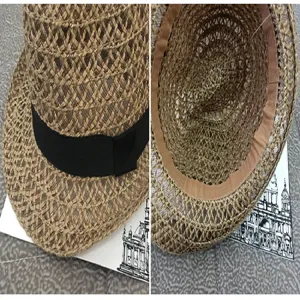 Close-up detail of women's straw sun hat with black band and interior sweatband