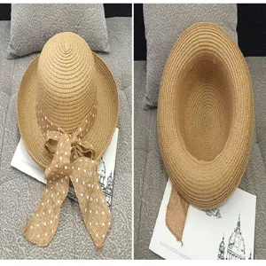 Close-up detail of wide brim straw sun hat with polka dot ribbon bow decoration