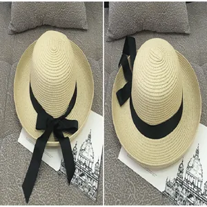 Detailed close-up view of two stylish woven straw beach hats featuring elegant black ribbons