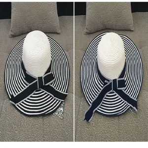 Detailed macro view showing two striped wide-brim straw sun hats with elegant decorative bows